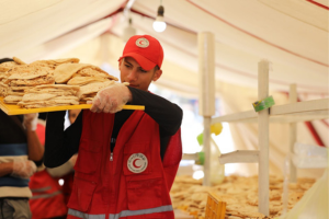 A volunteer carries bread that Egyptian Red Crescent delivered to people in Gaza during Ramadan.