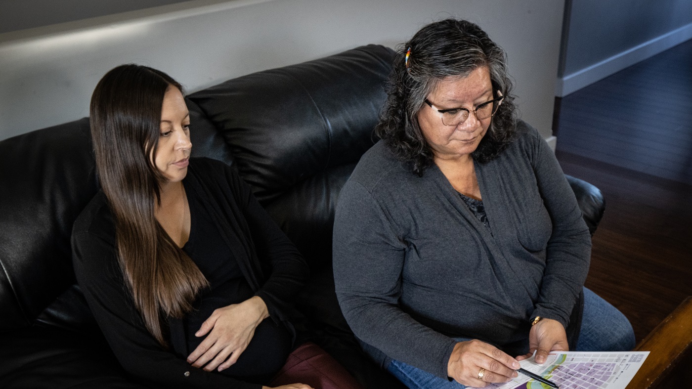 A pregnant woman and her mother review an emergency plan.