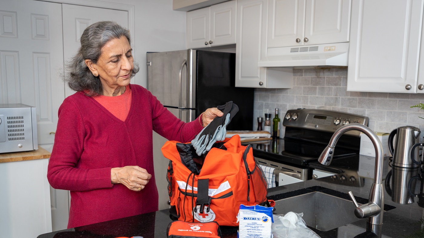 An older adult packs an emergency kit items for the kit are placed on display.